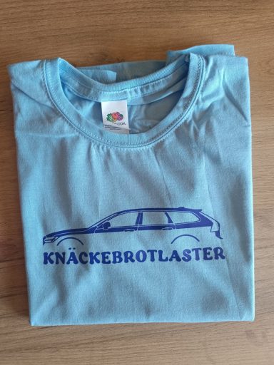 Volvo V90 Kids Knäckebrotlaster Hellblaues T-Shirt mit dem Aufdruck "KNACKEBROTLASTER" und Silhouette eines Autos.