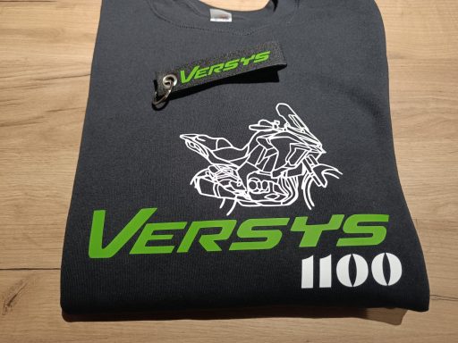 T-Shirt Versys Silhouette Schwarzes T-Shirt mit grünem "Versys 1100" und Motorrad-Illustration.