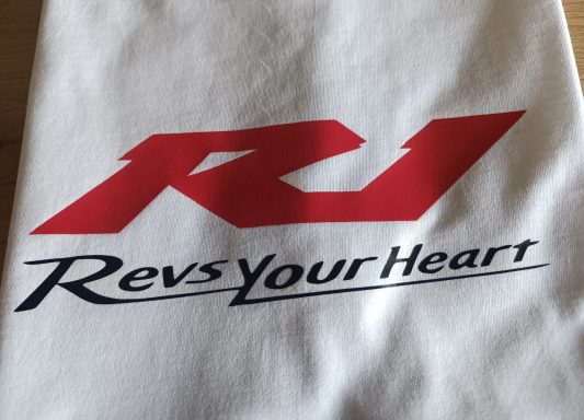 T-Shirt Yamaha YZF R1 Logo mit den Buchstaben "R1" und dem Slogan "Revs Your Heart" in Rot und Schwarz.